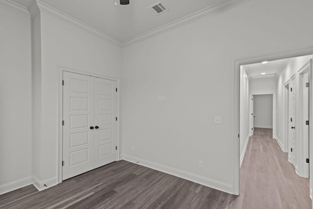 unfurnished room with wood-type flooring, ornamental molding, and ceiling fan