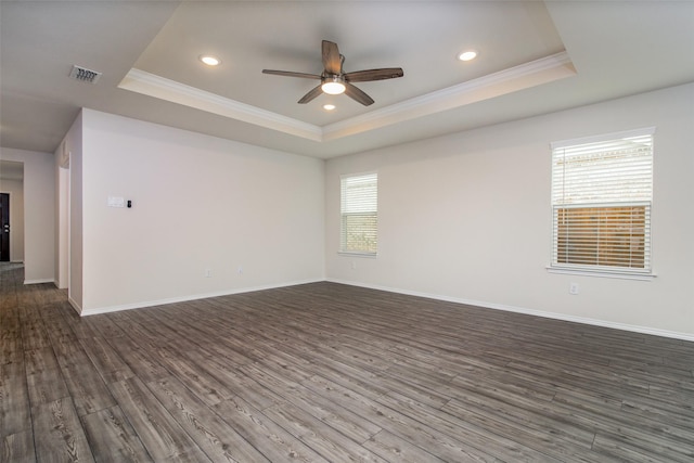 spare room featuring a raised ceiling, ceiling fan, dark hardwood / wood-style flooring, and crown molding