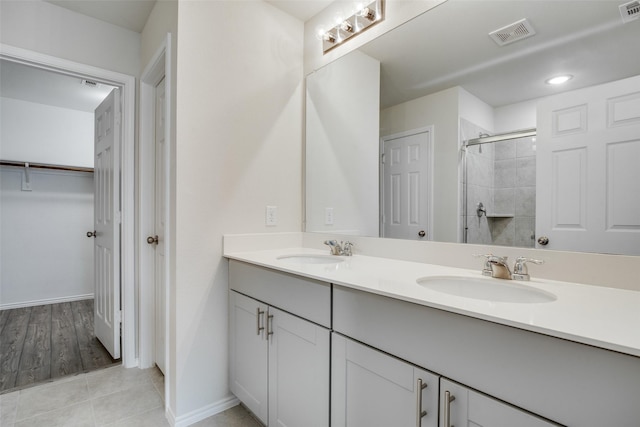 bathroom with a shower with door and vanity