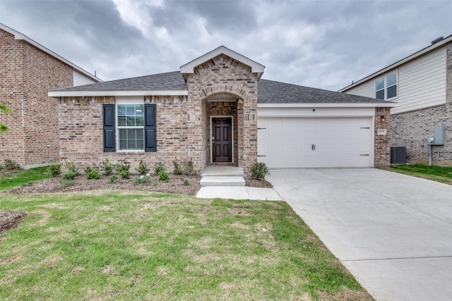 view of front of property with central AC, a front lawn, and a garage