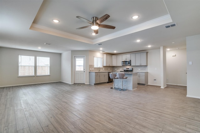 kitchen featuring a breakfast bar, a center island, and a raised ceiling