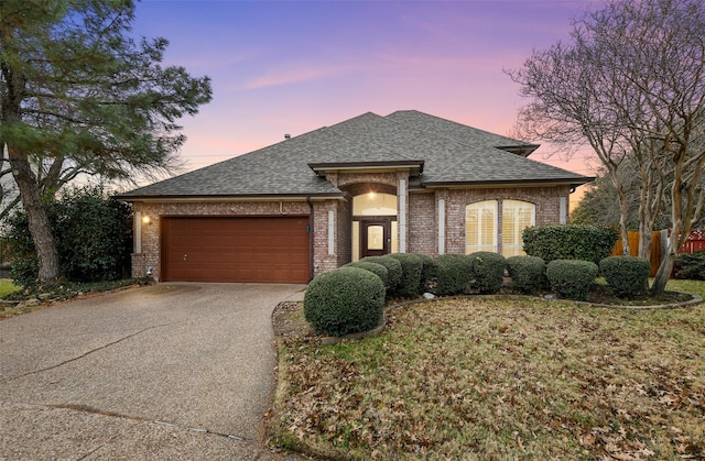 view of front of property featuring a garage and a yard