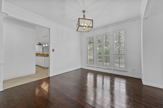 empty room with an inviting chandelier, light hardwood / wood-style flooring, and ornamental molding