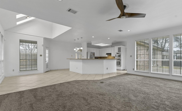 unfurnished living room featuring ceiling fan, light colored carpet, and lofted ceiling