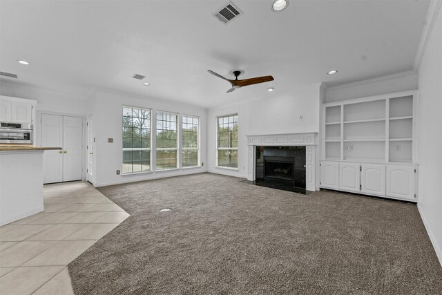 unfurnished living room featuring light tile patterned floors, ornamental molding, and ceiling fan