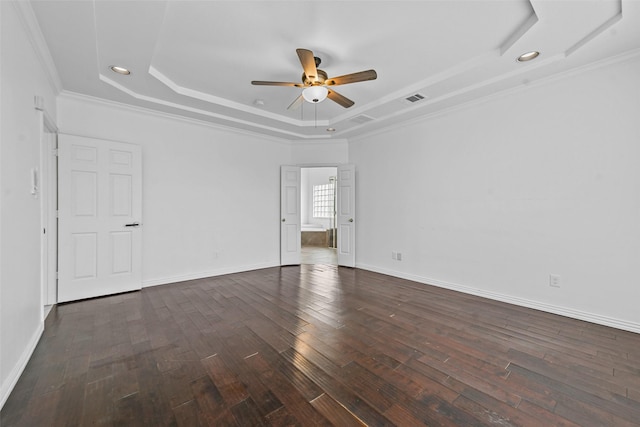 spare room with ornamental molding, dark wood-type flooring, ceiling fan, and a tray ceiling