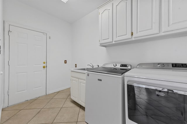 laundry area with light tile patterned flooring, independent washer and dryer, sink, and cabinets