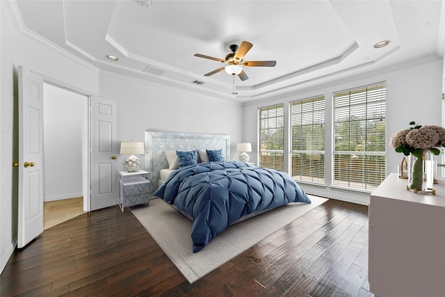 bedroom with crown molding, a tray ceiling, and ceiling fan