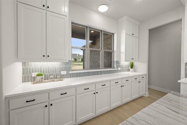 bar featuring tasteful backsplash, baseboards, and light wood finished floors