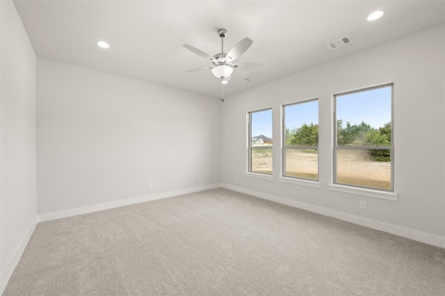 carpeted empty room featuring baseboards, visible vents, recessed lighting, and a ceiling fan