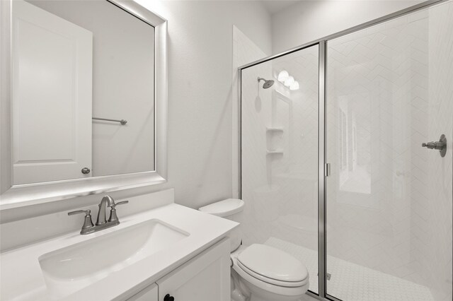 bathroom with toilet, vanity, and a shower stall