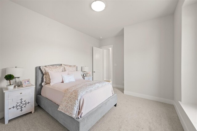 bedroom featuring light carpet and baseboards