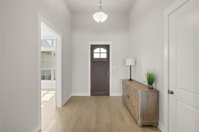 entryway with baseboards and light wood-style flooring