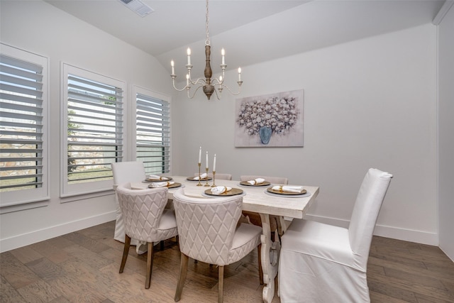 dining room with lofted ceiling, dark hardwood / wood-style floors, and an inviting chandelier