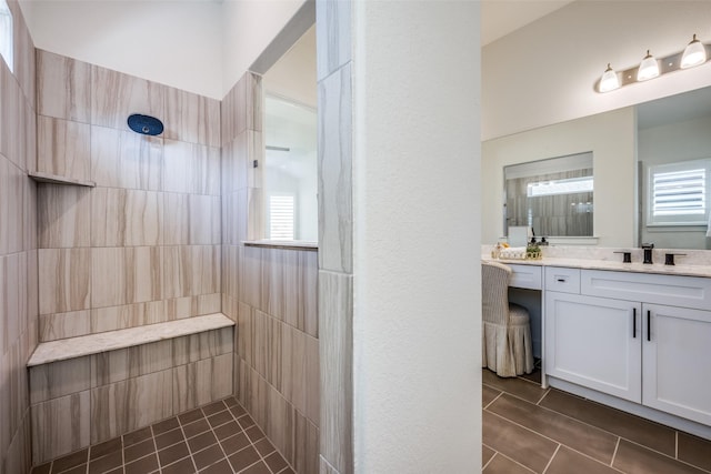 bathroom with vanity, plenty of natural light, and a tile shower