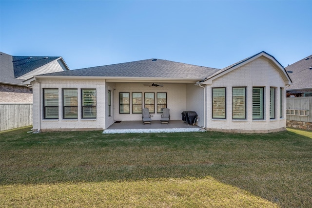 rear view of property with a yard, a patio, and ceiling fan