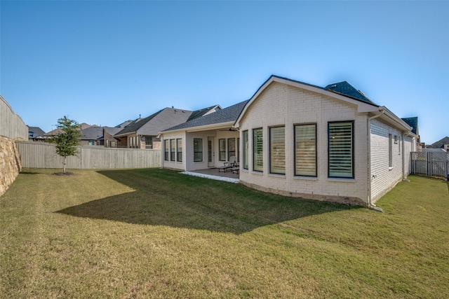 rear view of house featuring a patio and a lawn