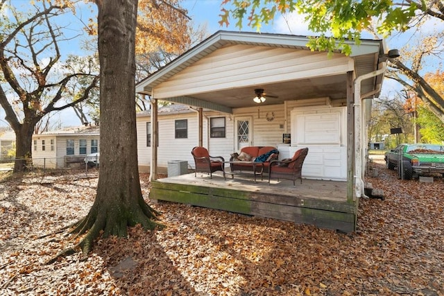 rear view of house featuring ceiling fan, an outdoor hangout area, and a wooden deck