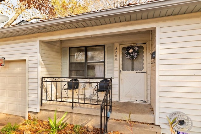 property entrance featuring covered porch and a garage