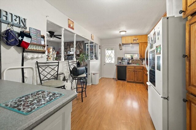 kitchen with dishwasher, white fridge, light hardwood / wood-style flooring, and ceiling fan