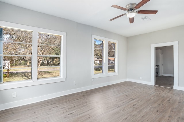 spare room with hardwood / wood-style floors, ceiling fan, and a wealth of natural light