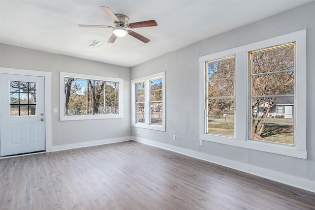 spare room with hardwood / wood-style floors, a wealth of natural light, and ceiling fan