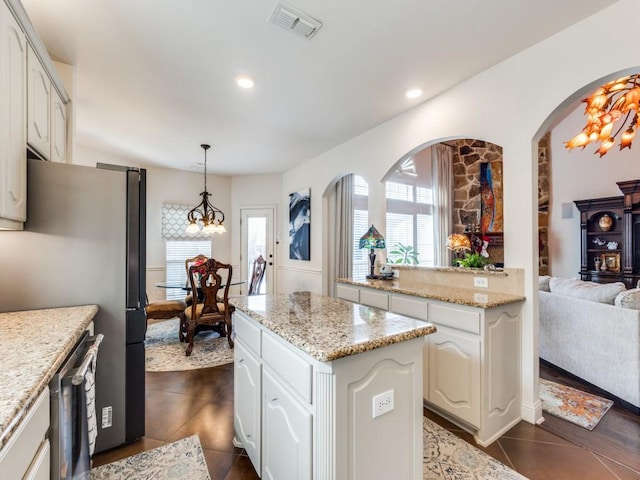 kitchen featuring dark tile patterned flooring, decorative light fixtures, white cabinetry, and an inviting chandelier