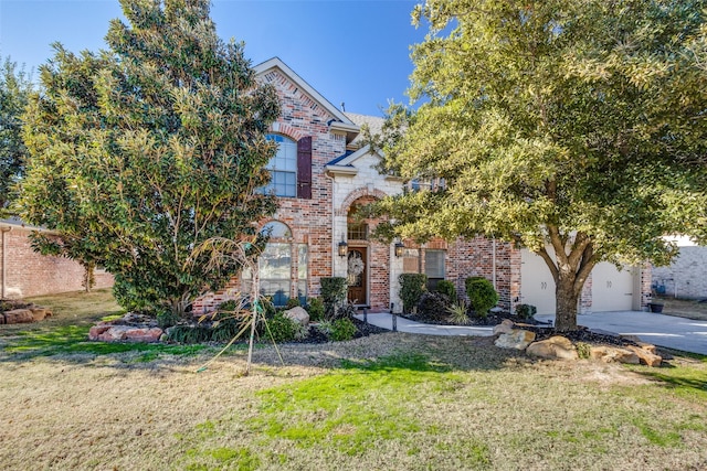 view of front of home featuring an attached garage, a front yard, concrete driveway, and brick siding