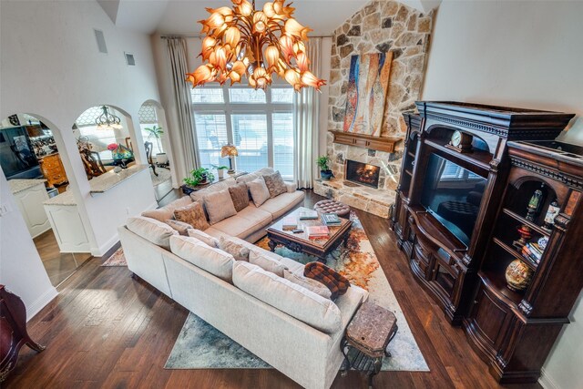 living room featuring a towering ceiling, a chandelier, and dark hardwood / wood-style floors