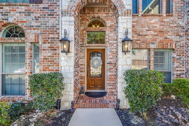 view of exterior entry with brick siding