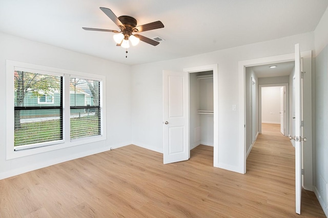 unfurnished bedroom featuring a closet, light hardwood / wood-style flooring, and ceiling fan