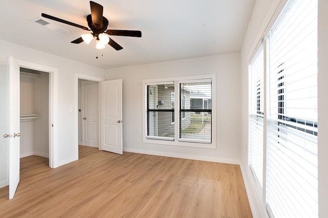 unfurnished bedroom with light wood-type flooring, a closet, and ceiling fan