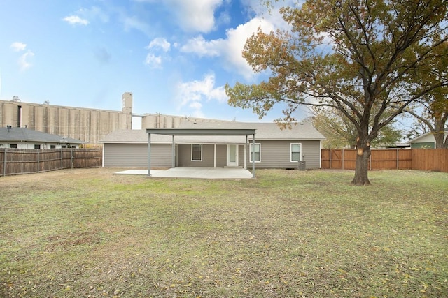 rear view of house with a lawn and a patio