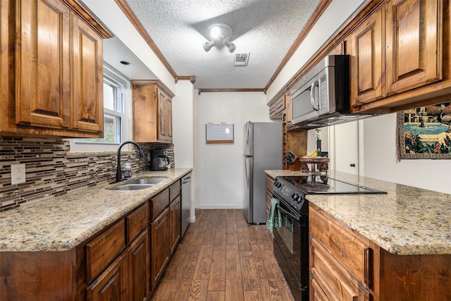 kitchen featuring dark wood-type flooring, crown molding, sink, a textured ceiling, and stainless steel appliances