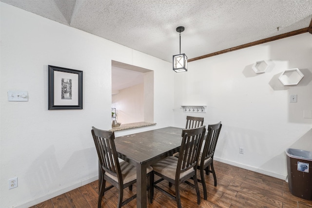 dining area featuring dark hardwood / wood-style flooring and a textured ceiling