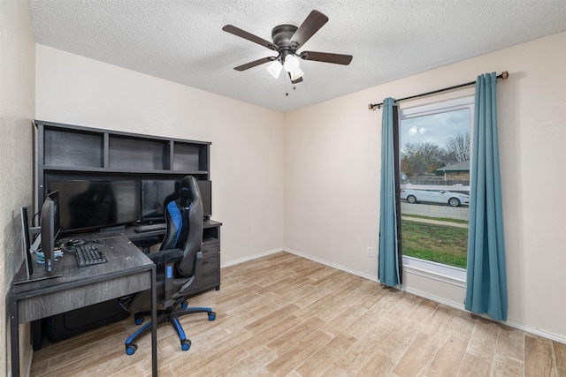 office area with a textured ceiling, light hardwood / wood-style flooring, and ceiling fan