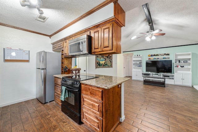 kitchen with a textured ceiling, appliances with stainless steel finishes, and dark wood-type flooring