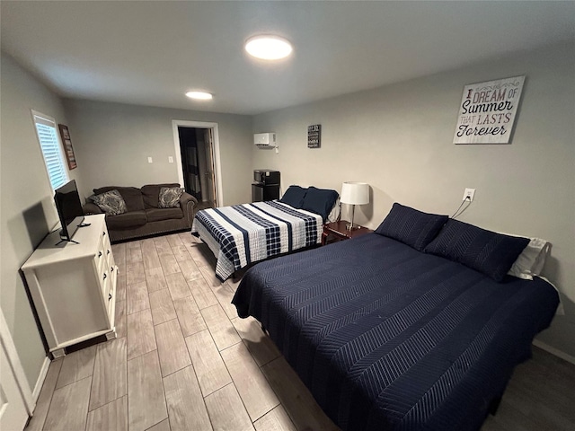 bedroom with light wood-type flooring and an AC wall unit