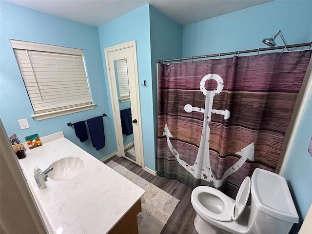 bathroom featuring vanity, hardwood / wood-style floors, walk in shower, and toilet