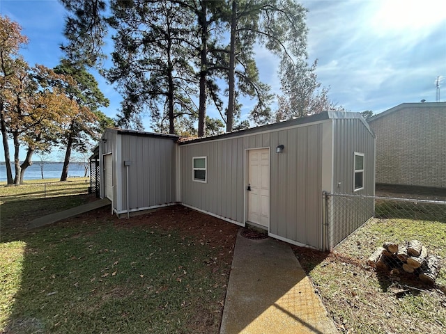 view of outbuilding featuring a water view and a lawn