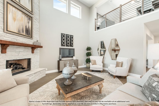 living room featuring a fireplace, dark hardwood / wood-style flooring, and a towering ceiling