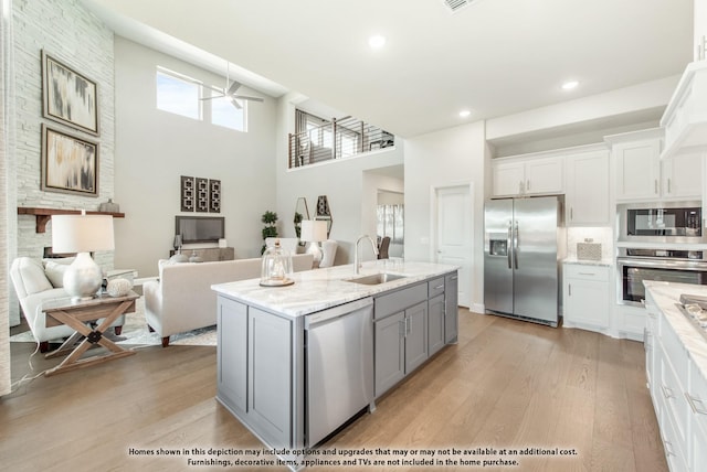 kitchen featuring gray cabinetry, sink, a towering ceiling, white cabinetry, and stainless steel appliances