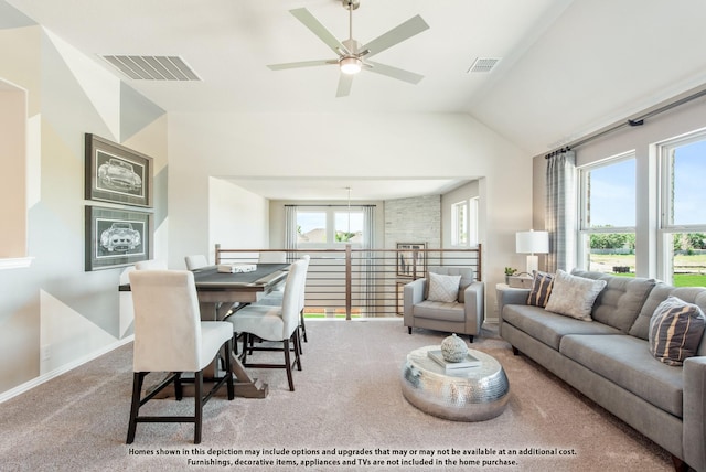 living room with a wealth of natural light, ceiling fan, light carpet, and lofted ceiling