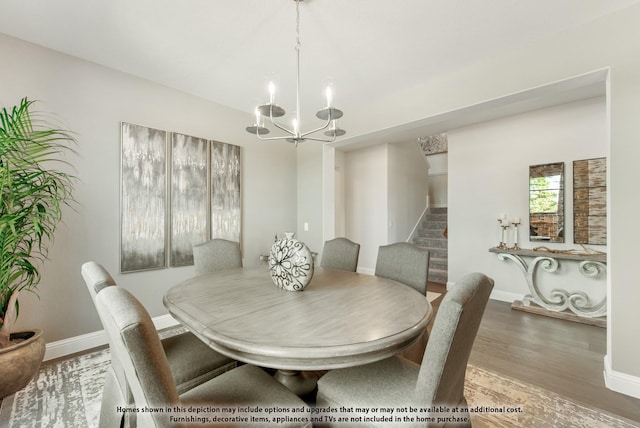 dining space with hardwood / wood-style floors and a notable chandelier