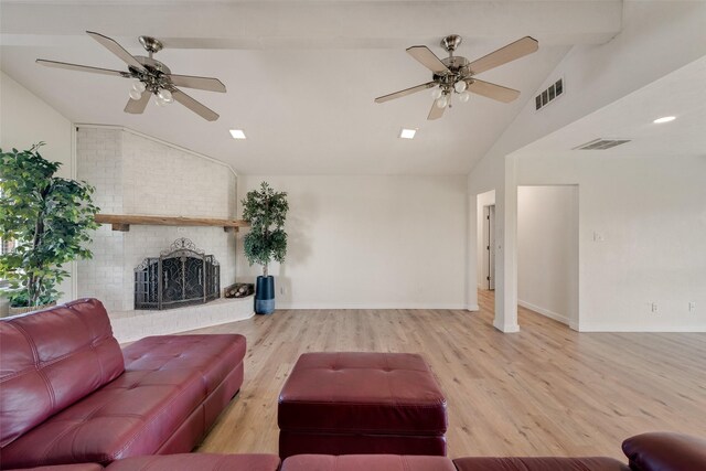 living room featuring a brick fireplace, ceiling fan, light hardwood / wood-style floors, and vaulted ceiling