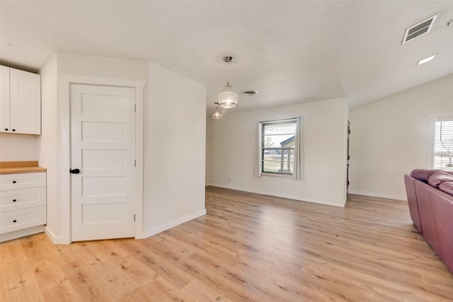 unfurnished living room with lofted ceiling and light hardwood / wood-style flooring