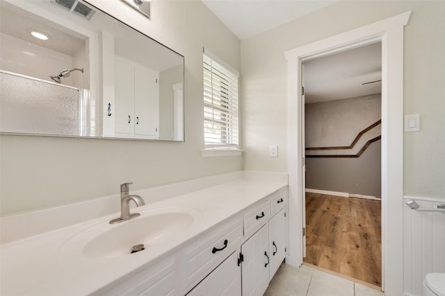 bathroom with hardwood / wood-style flooring, vanity, and a shower