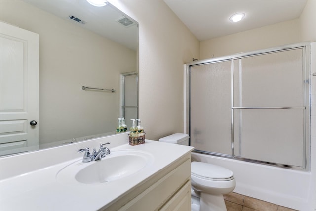 full bathroom featuring tile patterned floors, shower / bath combination with glass door, vanity, and toilet