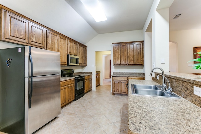 kitchen featuring light tile patterned floors, stainless steel appliances, vaulted ceiling, and sink