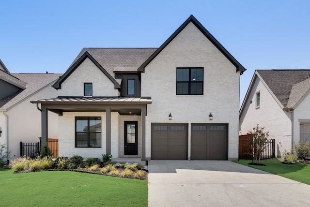 view of front of property featuring covered porch, a garage, and a front lawn